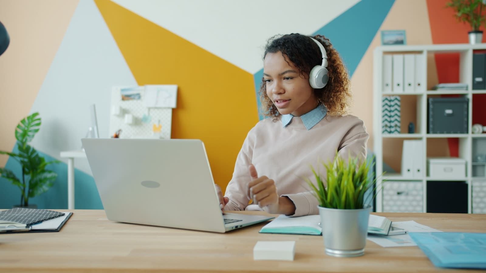 Person working on a laptop with headphones on, listening to focus music